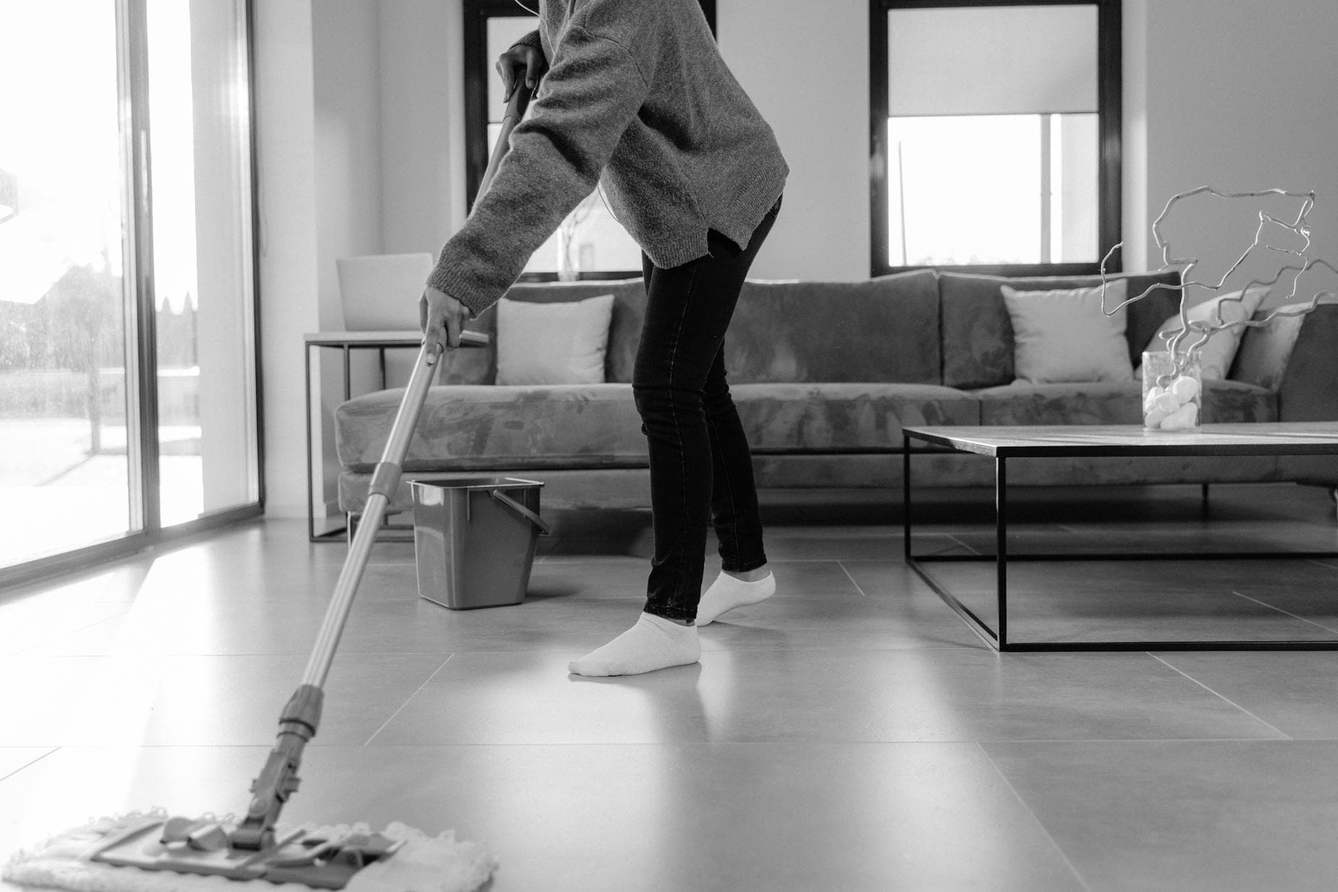 Professional NYC cleaner mopping the floor in a modern apartment living room — Regular Apartment Cleaning in Bedford, Westchester