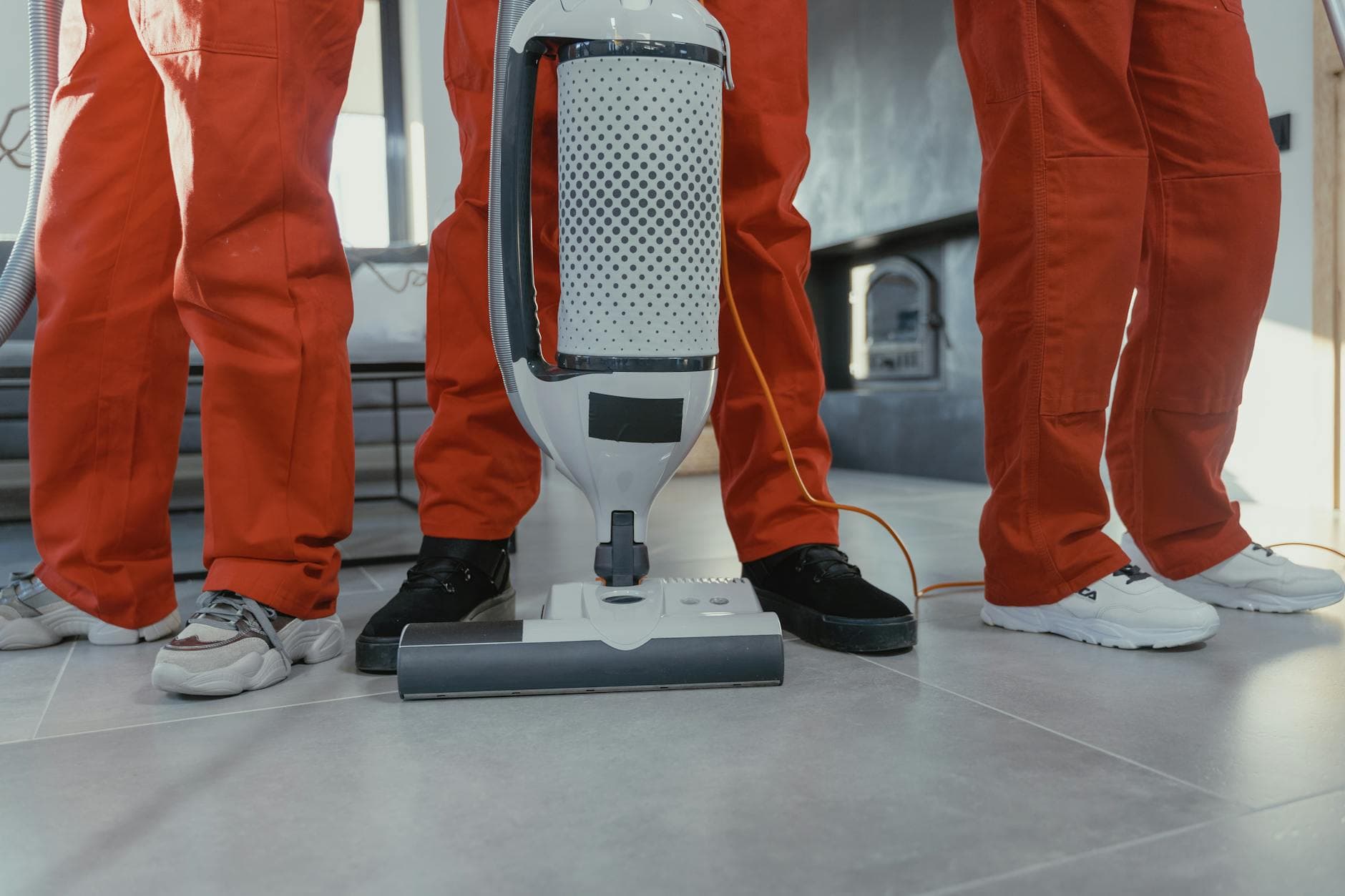 A team of professional NYC Maid cleaners in red uniforms using a vacuum in a New York home — Same-Day Cleaning in Financial District, Manhattan