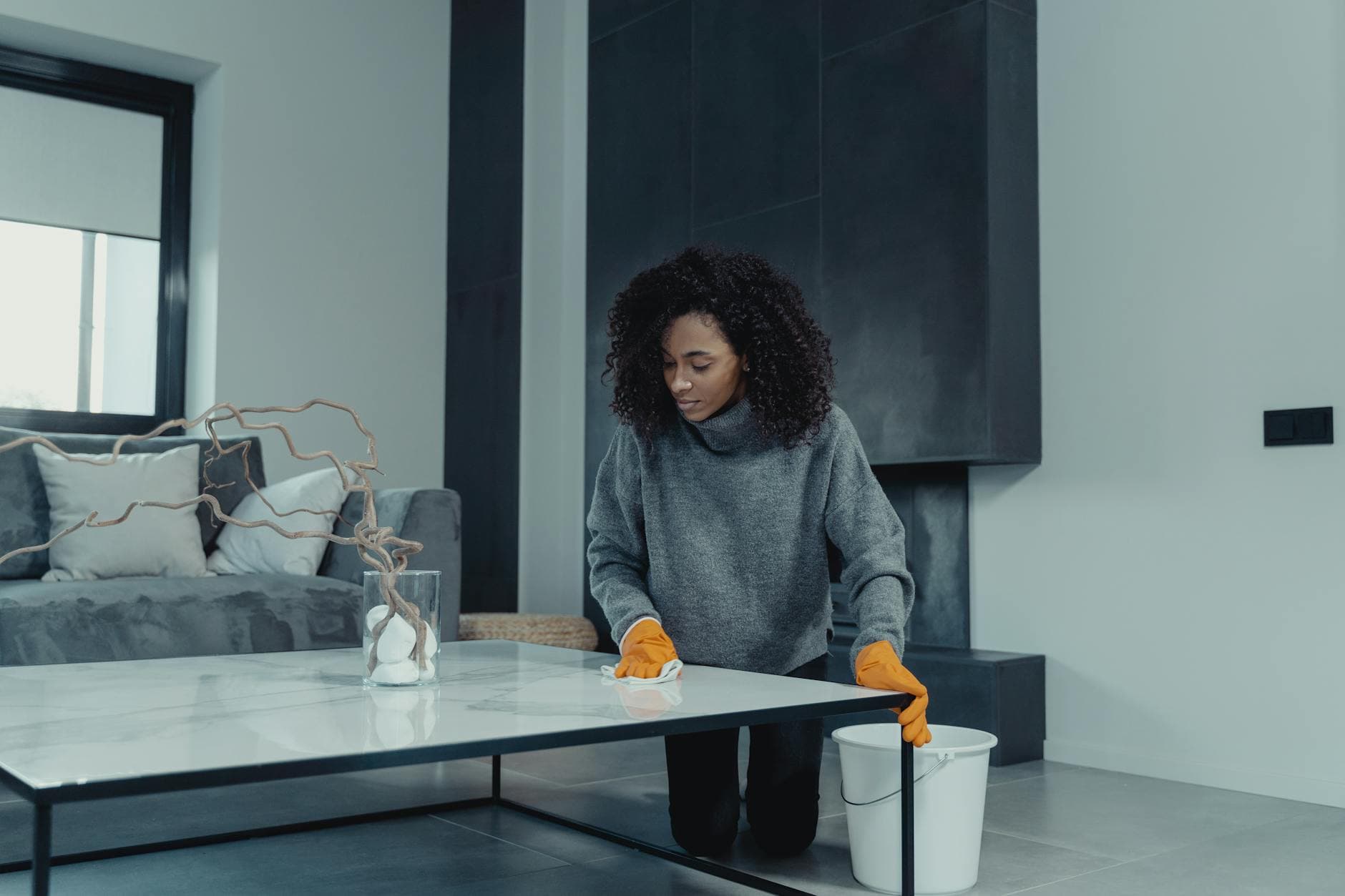 Professional house cleaner wiping a table in a contemporary New York apartment — cleaning services in Hunts Point, Bronx