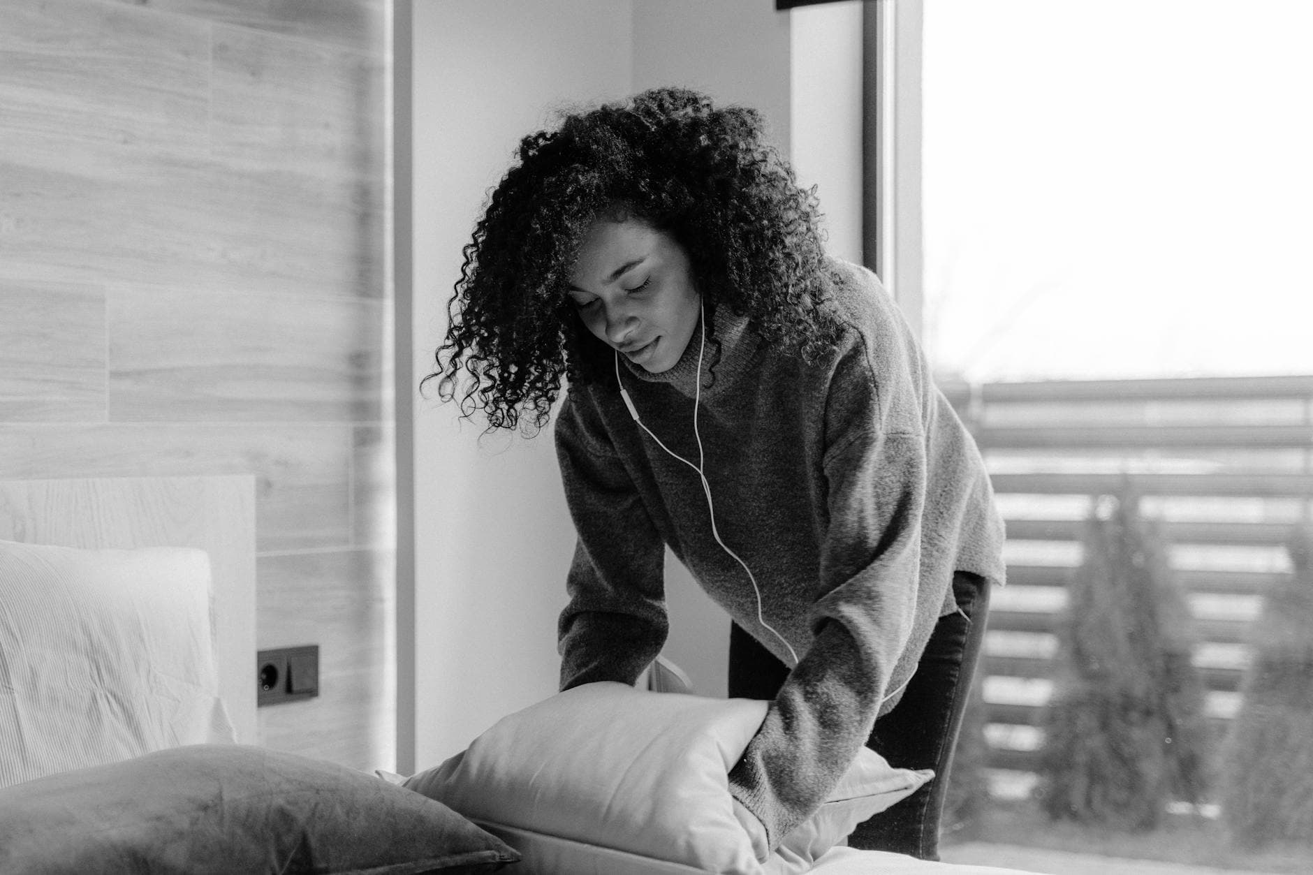 NYC maid service making the bed in a bright, monochrome bedroom — Airbnb & Short-Term Rental Cleaning in Todt Hill, Staten Island
